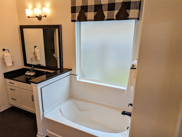 bathroom featuring tile flooring, vanity with extensive cabinet space, and a washtub