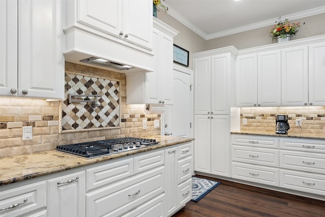 kitchen with stainless steel gas stovetop, light stone countertops, white cabinets, backsplash, and dark hardwood / wood-style flooring