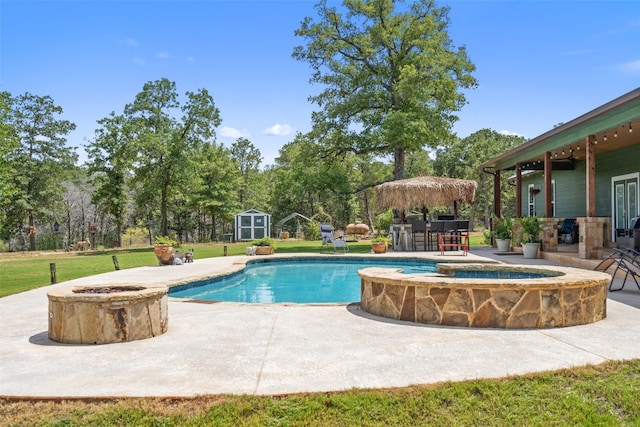 view of pool with a yard, a shed, an outdoor fire pit, and a patio