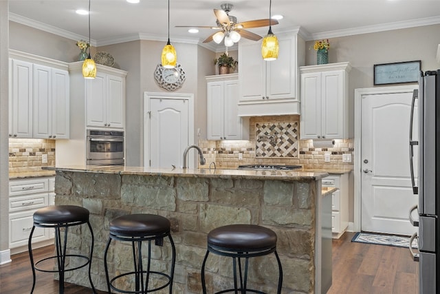 kitchen with dark hardwood / wood-style floors, stainless steel appliances, white cabinetry, and light stone countertops