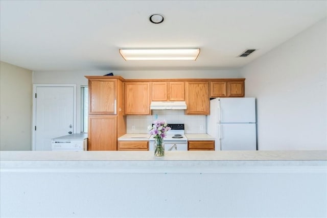 kitchen featuring backsplash and white appliances