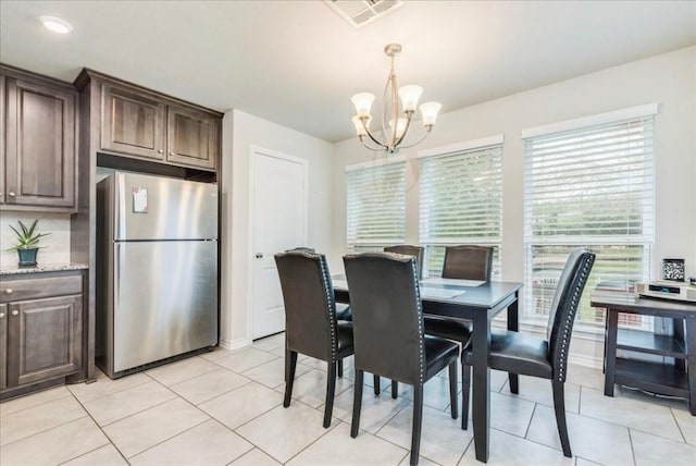 dining space with light tile patterned floors and a notable chandelier