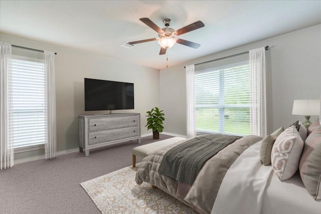 carpeted bedroom with multiple windows and ceiling fan