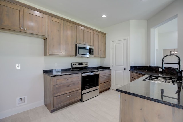 117 Callie St, Smithville, TX 78957 - kitchen featuring stainless steel appliances, a sink, dark stone countertops, recessed lighting, and baseboards