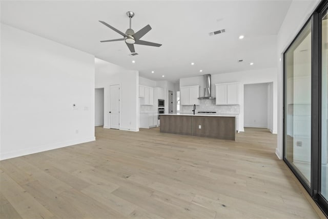 unfurnished living room featuring light hardwood / wood-style flooring and ceiling fan