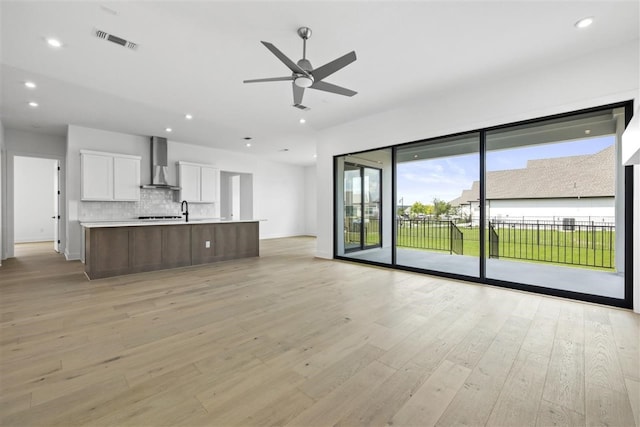 unfurnished living room featuring light wood-type flooring and ceiling fan