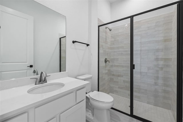 bathroom with vanity, toilet, and a shower with shower door