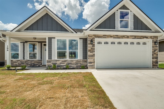 craftsman house with covered porch, a garage, and a front lawn