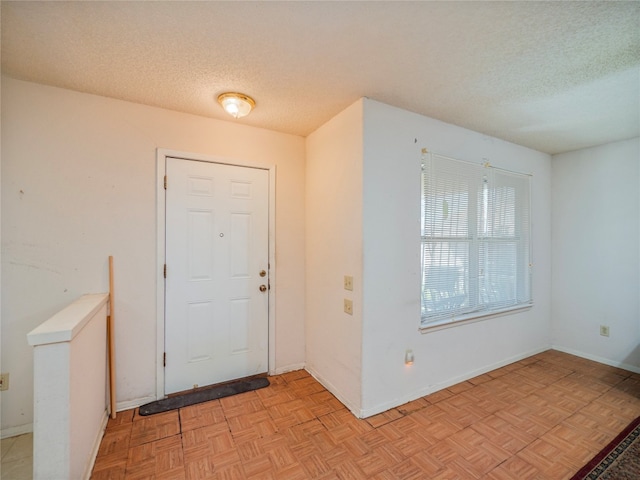 entryway featuring a textured ceiling and light parquet flooring