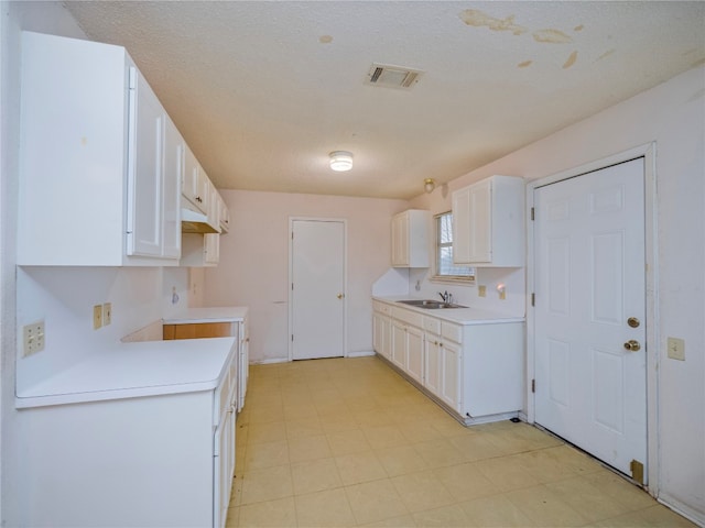 kitchen featuring white cabinets, sink, and light tile floors