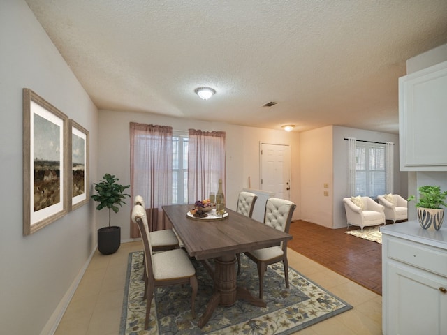 dining room with a textured ceiling and light tile floors