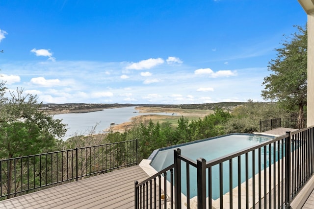 wooden deck with a fenced in pool and a water view