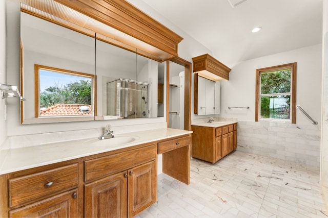 bathroom featuring a shower with door, vanity, and tile walls