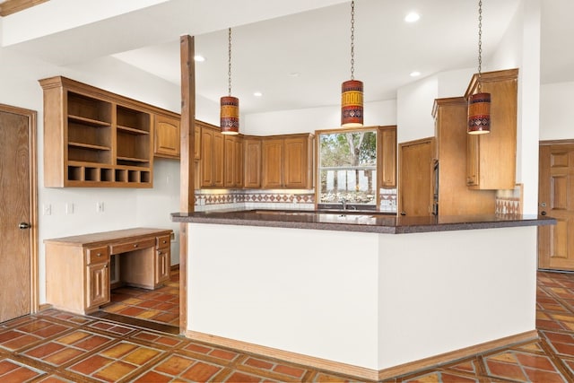 kitchen with pendant lighting, kitchen peninsula, sink, and backsplash