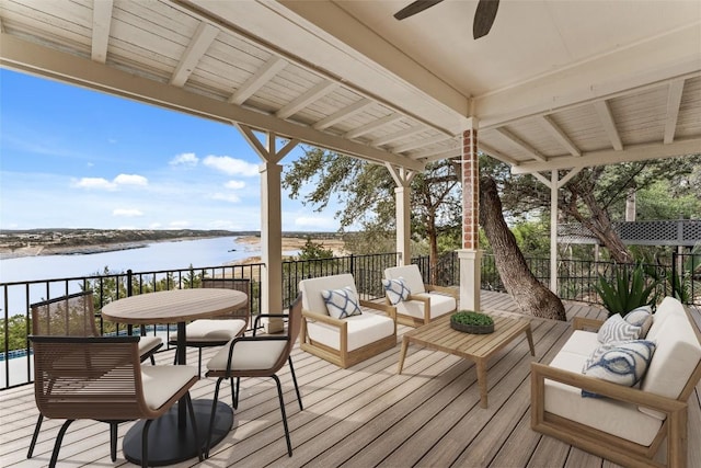 wooden deck featuring a water view, an outdoor hangout area, and ceiling fan