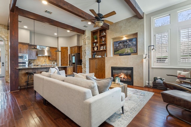 living room featuring built in shelves, dark wood-type flooring, ceiling fan, and beam ceiling