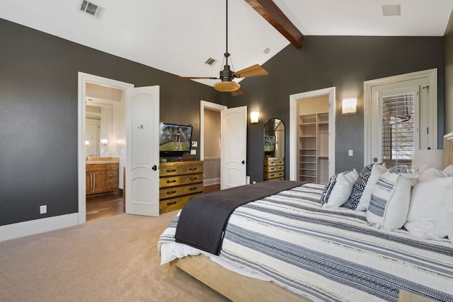 bedroom with light colored carpet, connected bathroom, beamed ceiling, a closet, and a spacious closet