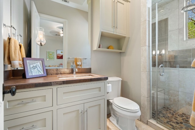 bathroom featuring toilet, tile floors, an enclosed shower, and vanity