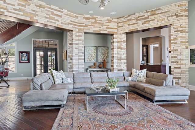 living room featuring dark wood-type flooring, a high ceiling, and french doors