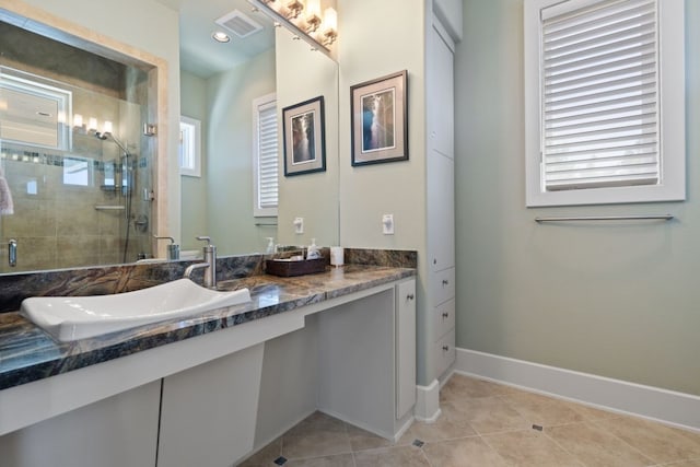 bathroom with tile patterned flooring, vanity, and a shower with door