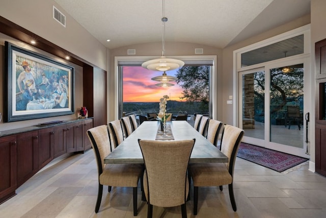 dining area featuring vaulted ceiling