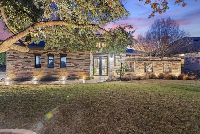 view of front of home with a lawn and french doors