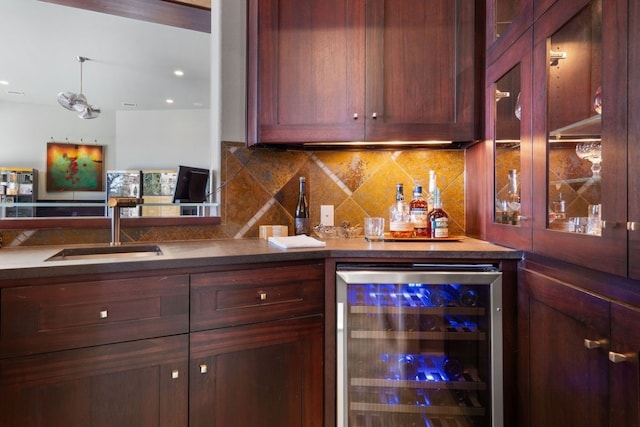 bar with backsplash, sink, and beverage cooler