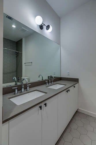 bathroom featuring vanity, tile patterned floors, and tiled shower