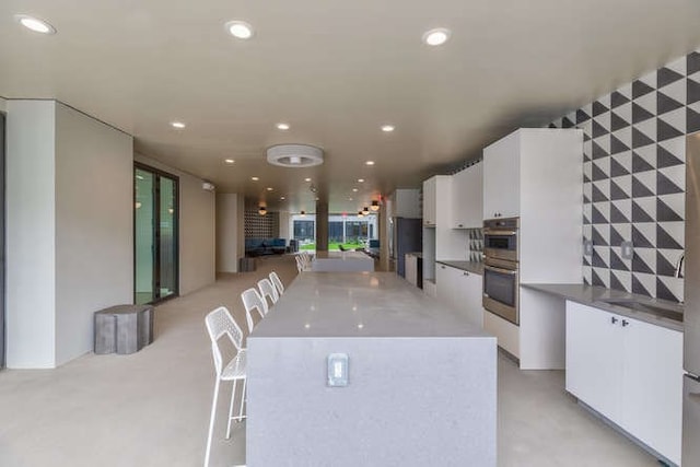 kitchen with white cabinetry, a center island, and double oven