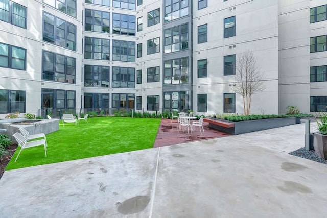 view of property's community with a patio and a yard