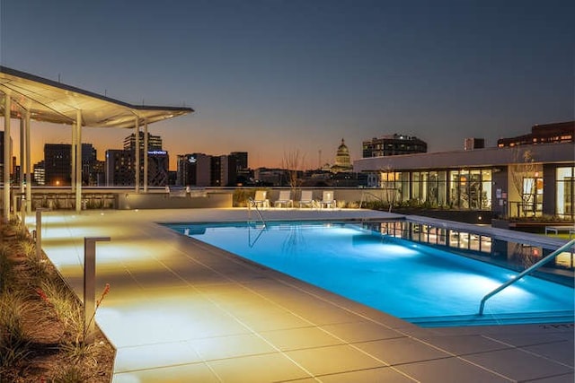 pool at dusk featuring a patio area