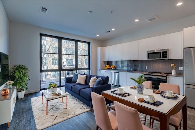 kitchen featuring sink, decorative backsplash, stainless steel appliances, and white cabinets