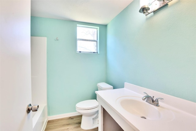 bathroom featuring toilet, vanity, and hardwood / wood-style flooring