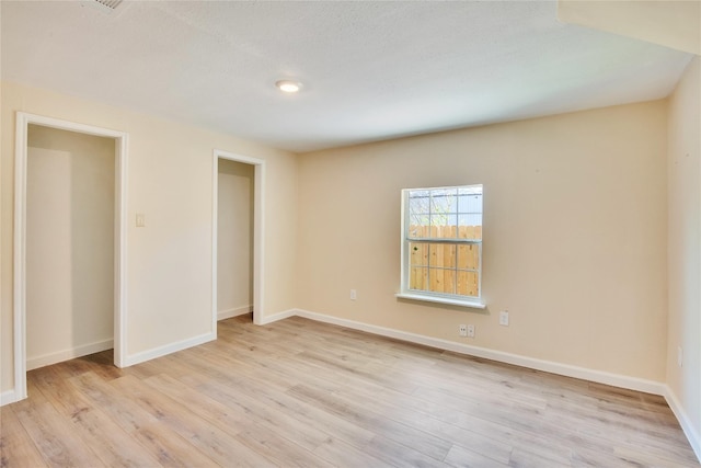 unfurnished bedroom with a closet and light wood-type flooring