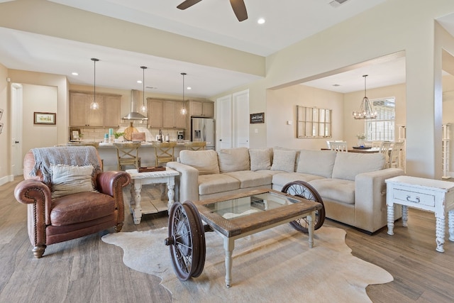 living room with dark hardwood / wood-style floors and ceiling fan with notable chandelier