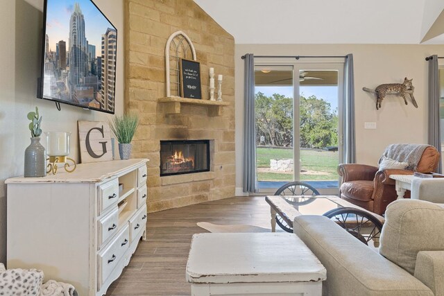 living room featuring dark hardwood / wood-style floors, a large fireplace, and vaulted ceiling