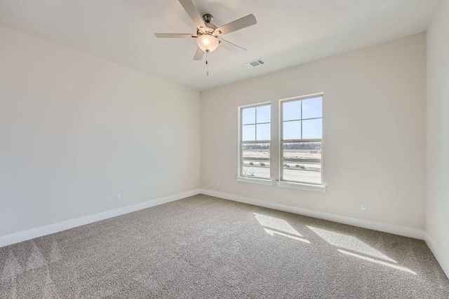 spare room with carpet floors, ceiling fan, and baseboards
