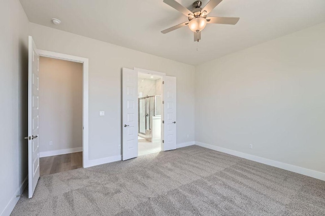 unfurnished bedroom with carpet floors, baseboards, ensuite bath, and a ceiling fan