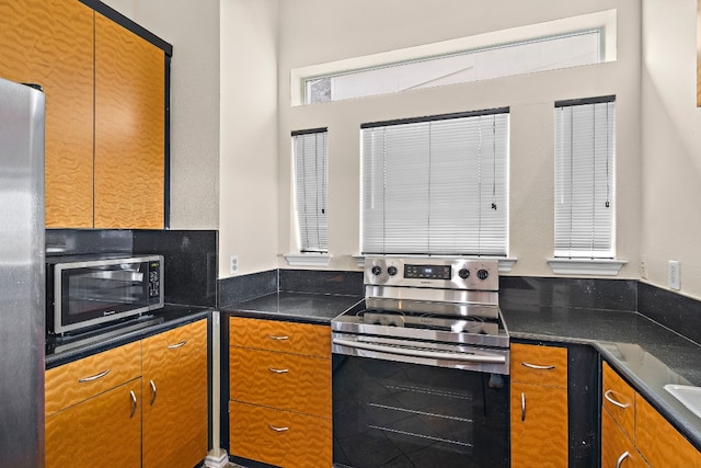 kitchen featuring stainless steel appliances and dark stone counters