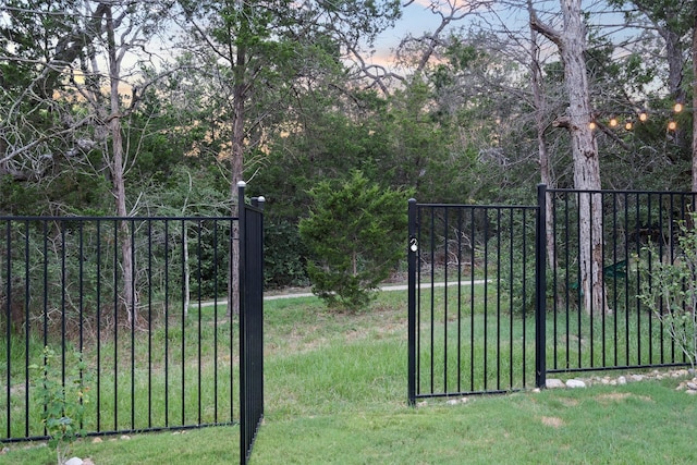 view of gate with a yard