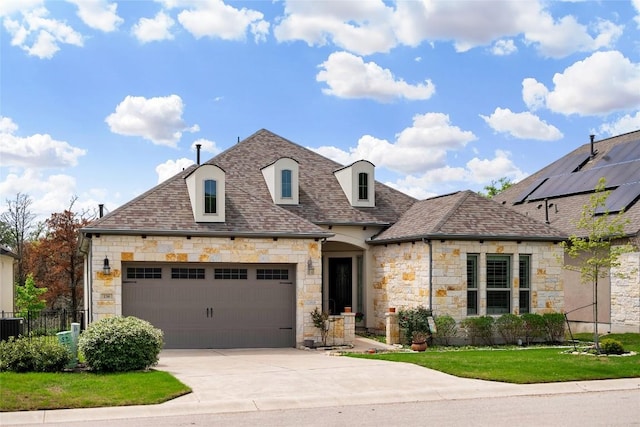 french country inspired facade featuring fence, stone siding, roof with shingles, an attached garage, and driveway