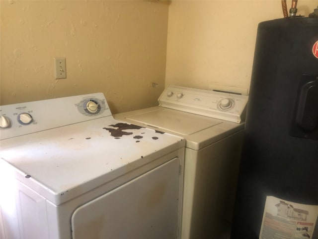 laundry room with water heater and washer and dryer