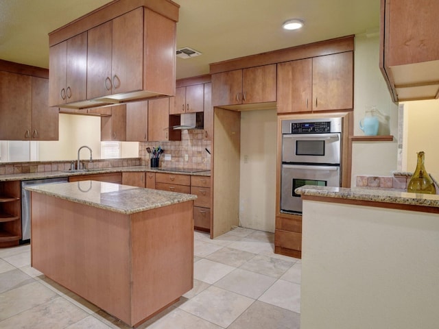 kitchen with backsplash, stainless steel appliances, light stone counters, sink, and light tile floors