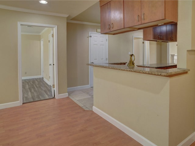 kitchen with crown molding, light stone countertops, light tile flooring, and kitchen peninsula