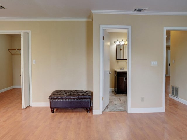 interior space featuring ornamental molding, sink, and light wood-type flooring