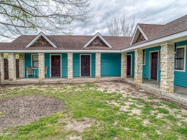 view of front of home with covered porch and a front lawn