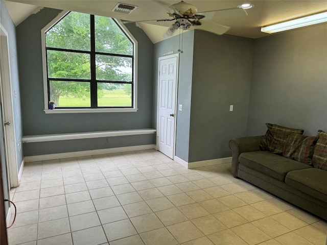 living room with a healthy amount of sunlight, vaulted ceiling, ceiling fan, and light tile floors