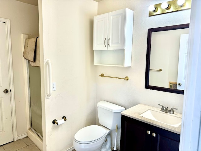 bathroom featuring a shower with door, vanity, toilet, and tile flooring