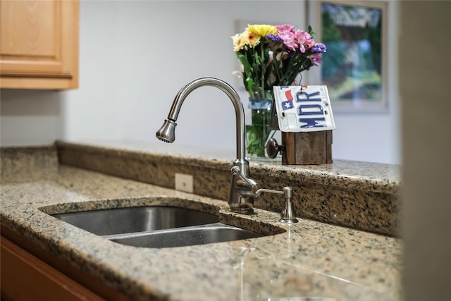 details with stone counters, sink, and light brown cabinetry