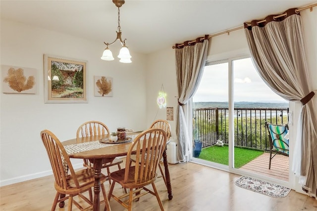 dining space featuring light wood-type flooring and a water view